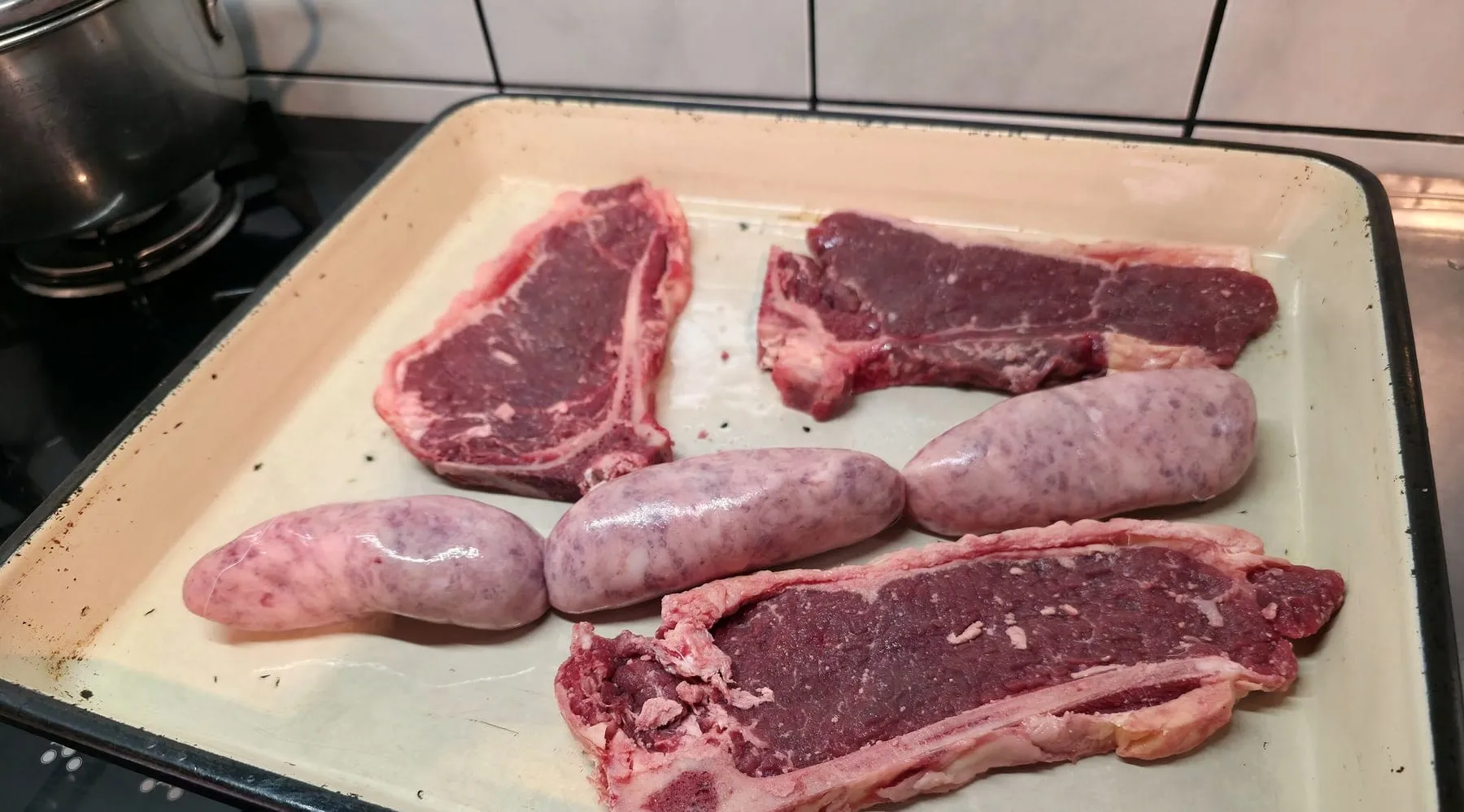 Bifes y chorizos crudos preparados para la parrilla